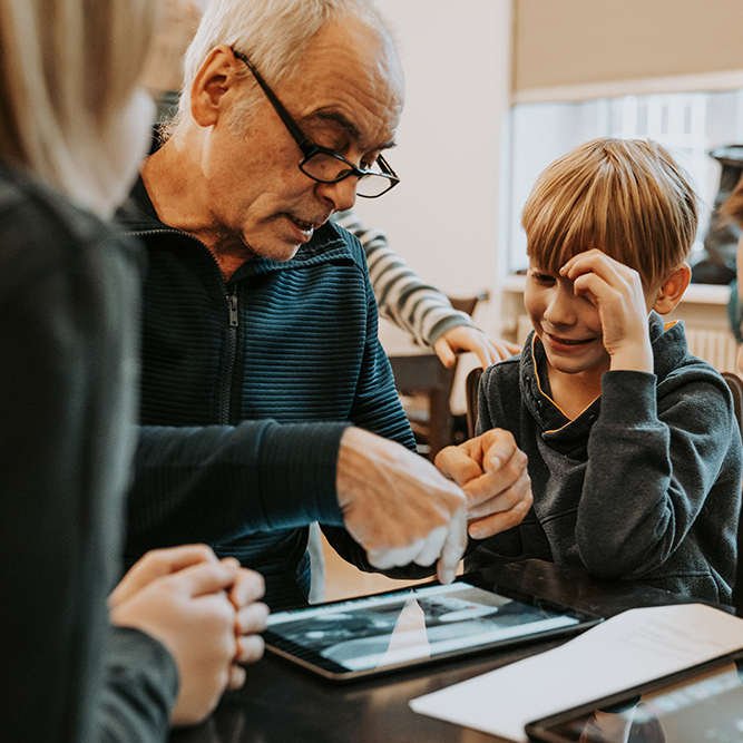 Kinder und Lehrkraft arbeiten am Tablet